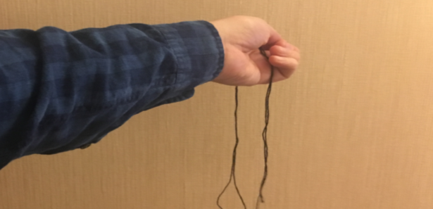 hand holding a strand of thread