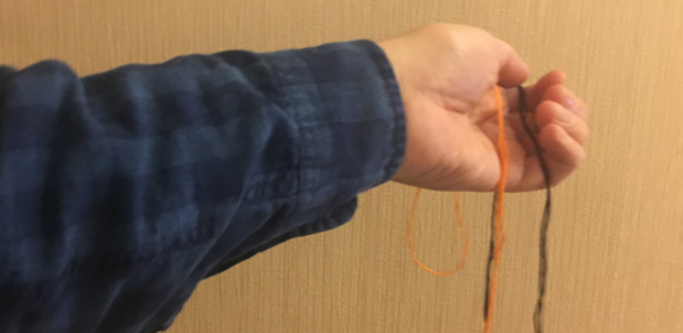hand holding a second strand of thread