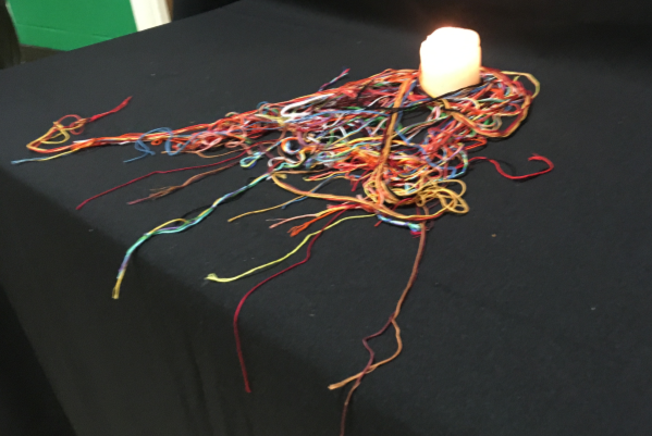 candle surrounded by threads